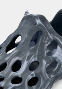 Γκρι, ημιδιάφανο παπούτσι με πολλαπλές κυκλικές οπές, ομαλή υφή και μοναδικό μοτίβο που μοιάζει με μάρμαρο. Φέρει την επωνυμία «Merrell».