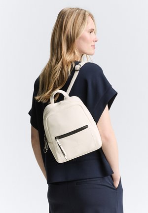Weißer Leder-Rucksack mit einer Reißverschlusstasche an der Vorderseite und einem oberen Griff, einseitig getragen, mit einer strukturierten Oberfläche und verstellbarem Riemen.