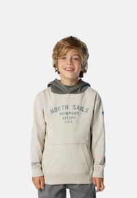 Sudadera con capucha beige con detalles en gris, bolsillo canguro delantero y logo "NORTH SAILS NEWPORT". Cuenta con puños y dobladillo acanalados.