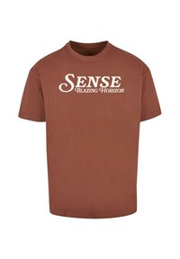 Barna pamut póló rövid ujjakkal és kerek nyakkivágással. Az elülső részén a "SENSE" és a "BLAZING HORIZON" felirat fehér, kontrasztos betűkkel.