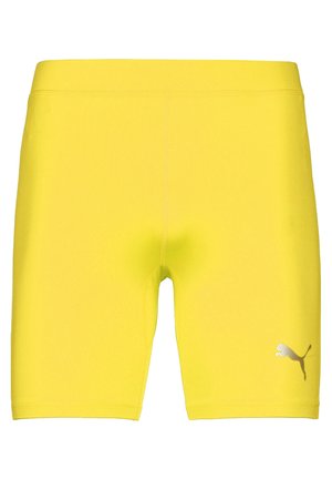 Helle gelbe Shorts aus dehnbarem Material, mit einer figurschmeichelnden Passform und einem kleinen silbernen Puma-Logo auf der unteren rechten Seite.