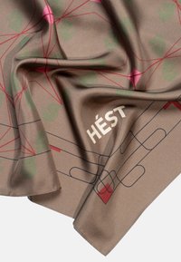 Silk skjerf i brun med grønne og rosa blomster mønstre. Har en logo "HÉST" i lys tekst og abstrakte linjemønstre. Myk tekstur.