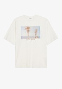 Cream-colored cotton t-shirt featuring a photo print of palm trees and a van, with the text "DREAMING OF SUMMER" below the image.