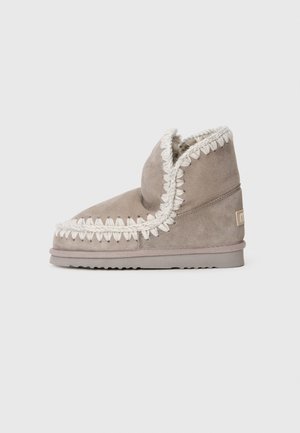 Stivaletti in suede grigio chiaro con cuciture bianche e interno morbido, caratterizzati da una punta arrotondata e una suola in gomma testurizzata.