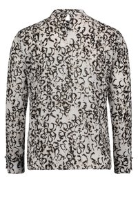 Long-sleeve blouse in lightweight fabric with a black and white abstract animal print, featuring a keyhole back detail and buttoned cuffs.