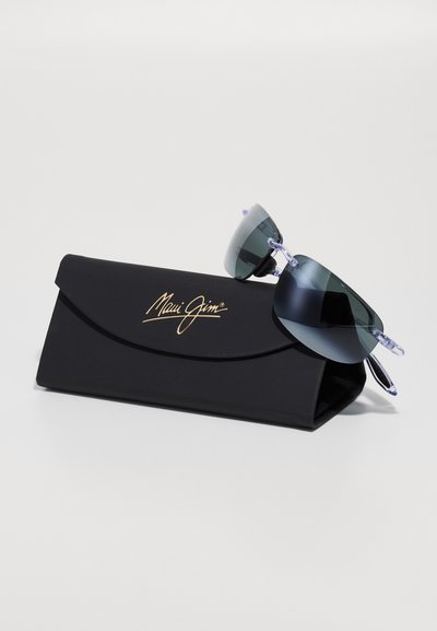 Sonnenbrille mit grauen Gläsern und klaren Bügeln, die auf einem schwarzen Etui mit goldenem "Maui Jim"-Logo, glatter Textur und rechteckiger Form liegen.