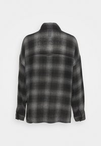 Košile s dlouhým rukávem, černá a šedá károvaná. Obsahuje límec, knoflíkové manžety a volný střih s texturovanou, mírně průsvitnou tkaninou.