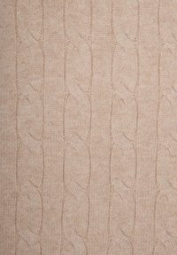 Tessuto lavorato a maglia beige caratterizzato da un motivo a treccia testurizzato con sezioni in rilievo e linee a coste alternate, che conferisce un aspetto morbido e caldo.