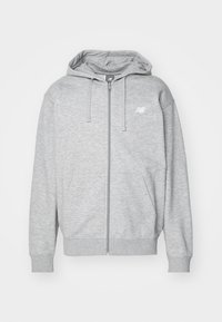 Grå zip-up hættetrøje lavet af blødt stof med en frontlynlås, to sidelommer, en hætte og et lille logo på venstre brystområde.