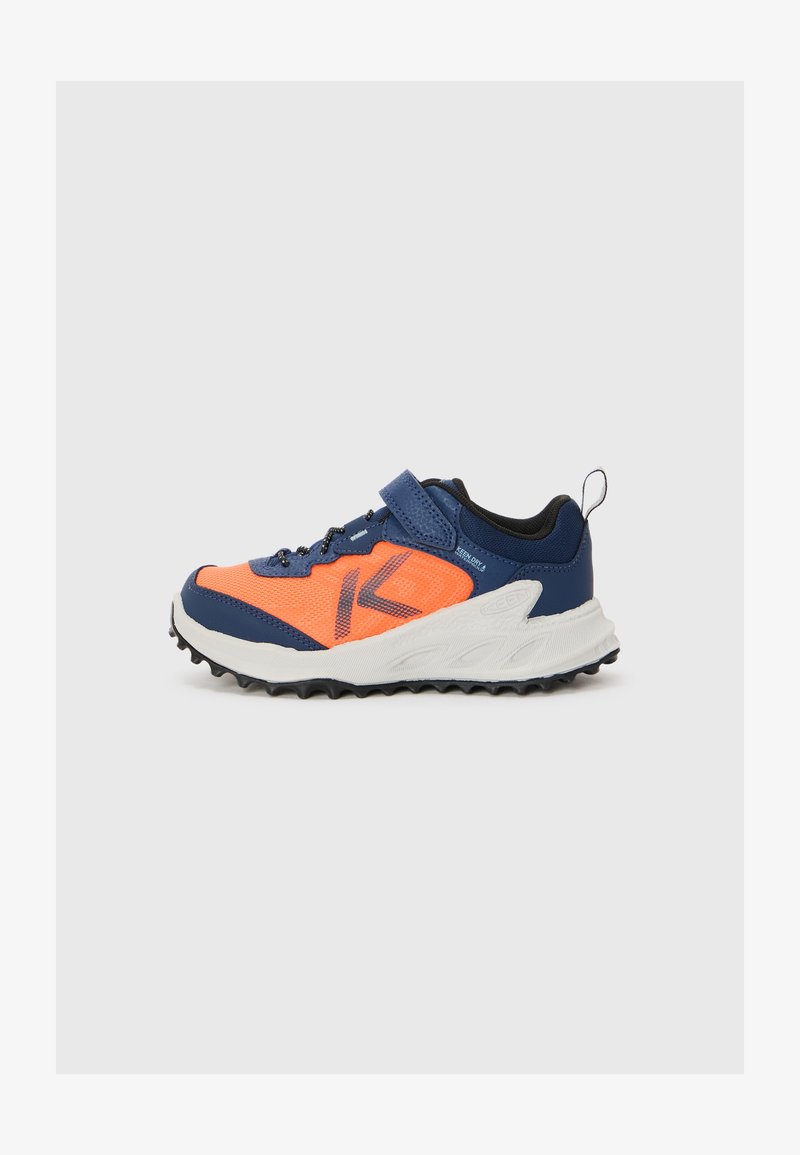 Niebieski i pomarańczowy but sportowy z siateczkową cholewką, rzepem, teksturowaną podeszwą oraz wyraźnym wzorem bieżnika zapewniającym przyczepność.