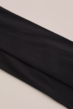 Czarna tkanina, miękka w dotyku, układająca się w fałdy, charakteryzująca się gładkim wykończeniem i jednolitym kolorem, odpowiednia do różnych typów odzieży.