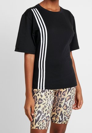 Schwarzes kurzärmliges T-Shirt mit drei weißen Streifen an einer Seite, kombiniert mit Radfahrshorts im Leopardenmuster, die strukturierte Muster zeigen.