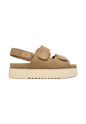 Beige ruskind åben tå sandal med kraftig hvid platformsål, justerbare velcroremme over foden og rundt om hælen.