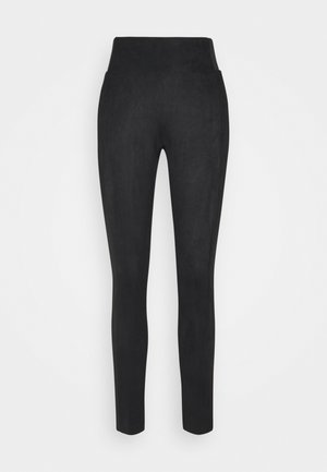 Leggings noirs extensibles en tissu doux et texturé. Taille haute sans coutures visibles, silhouette ajustée, se rétrécissant vers les chevilles.