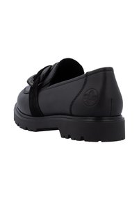 Mocassins en cuir noir pour femmes avec semelle épaisse, boucle décorative noire sur le dessus du pied et logo de la marque embossé sur le talon.