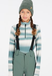 Lichtblauw en wit gestreepte long-sleeve zip-top met zwarte banden over groene skibroek met zakken en een getailleerd ontwerp.