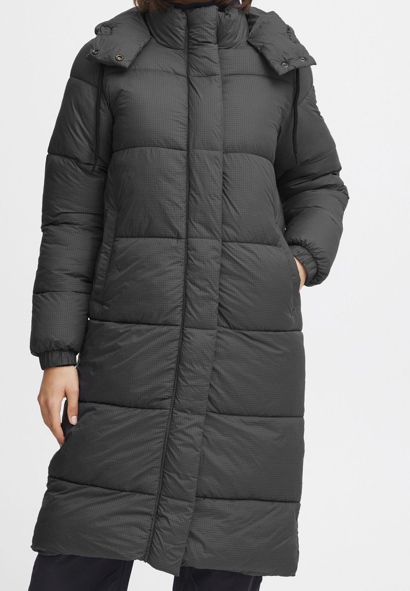 Abrigo largo acolchado en gris oscuro, con cuello alto, solapa abotonada, puños elásticos y una textura acolchada con grandes cuadros.