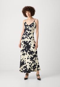 Mustavalkoinen täplikas print maxi-mekko ohutrannekkate ja V-pääntie, sujuvasta kankaasta, yhdistettynä mustiin teräväkärkisiin korkokenkiin.