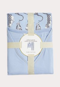 Pyjamas en coton bleu clair à manches longues, avec un motif léopard. Emballés dans un ruban doré et un label circulaire détaillant les informations sur le produit.