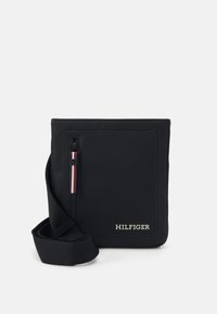 Borsa messenger nera con superficie testurizzata, tasca anteriore con zip e accenti rosso, bianco e blu, e tracolla. Logo sulla parte anteriore.