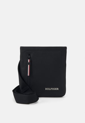 Borsa messenger nera con superficie testurizzata, tasca anteriore con zip e accenti rosso, bianco e blu, e tracolla. Logo sulla parte anteriore.