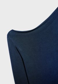 Haut bleu marine à encolure dégagée avec un tissu doux et texturé. Comprend des manches courtes et une silhouette décontractée et fluide.