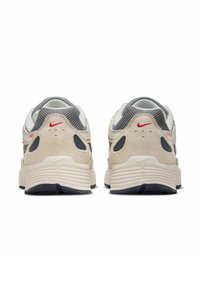 Light gray suede and mesh sneakers with a padded collar, white midsole, and black rubber outsole. Red Nike logo on the heel.