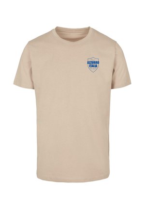 Tricou din bumbac bej cu mâneci scurte, având un logo în formă de scut albastru pe care scrie "AZZURRO ITALIA" în zona stângă a pieptului.