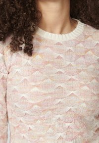 Suéter de punto con un patrón de olas en forma de concha en tonos pastel de rosa y amarillo, con un cuello blanco acanalado y una textura suave.