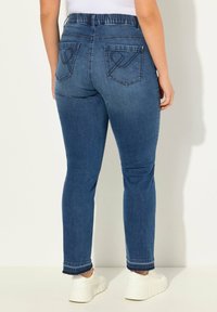 Modré džíny skinny s vysokým elastickým pasem, dvěma zadními kapsami, kontrastním prošíváním a mírně roztrhaným lemem.