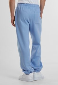 Helle blaue Sweatpants aus weichem Stoff mit einem tapered ankle Design und elastischem Bund. Enthält eine Gesäßtasche zur Aufbewahrung.