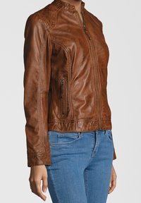Braune Lederjacke mit tailliertem Design, hohem Kragen und seitlichen Reißverschlusstaschen. Weicher Griff und Nahtdetails an den Schultern.
