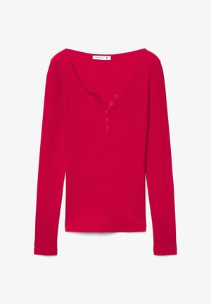 Maglietta rossa a maniche lunghe in tessuto coste, con scollo ampio e apertura frontale con quattro bottoni henley. Taglio dritto e tessuto morbido.