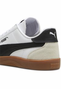 Hvide lædersneakers med sort ruskindselement og gummirubber-sål. Har PUMA-logo på siden og hælen, samt polstret krave for komfort.