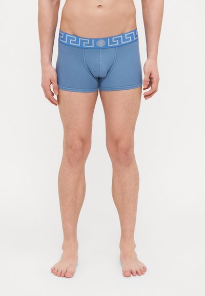 Boxeri din bumbac albastru, cu un elastic cu model albastru. Designul include un logo și o formă ajustată, cu o textură netedă.