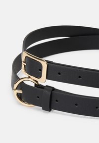 Cinto de couro preto com uma fivela retangular dourada e um detalhe de metal circular, com vários buracos para ajuste de tamanho.