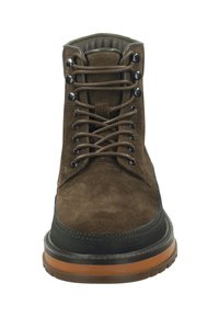 Brown suede ankle boot with black rubber sole, featuring metal eyelets, round laces, and a cushioned collar for comfort.