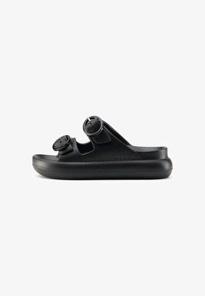 Sandalia slide negra con dos correas ajustables con hebilla y una suela gruesa acolchada mostrada de lado sobre un fondo blanco.