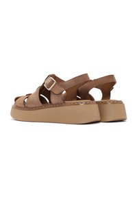 Sandali in suede marrone con una piattaforma chunky beige, design con punta aperta, dettagli ritagliati e una cintura con fibbia alla caviglia per una vestibilità sicura.