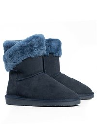 Stivaletti alla caviglia blu navy in morbido camoscio con un bordo in pelliccia sintetica. Il design presenta una suola piatta in gomma e dettagli cuciti.