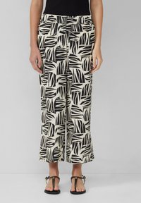 Pantalons larges à motifs noir et blanc avec un design de feuilles, dotés d'une taille élastique et d'un tissu doux et texturé.