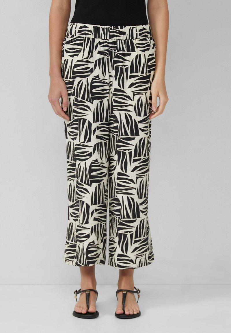 Pantalons larges à motifs noir et blanc avec un design de feuilles, dotés d'une taille élastique et d'un tissu doux et texturé.