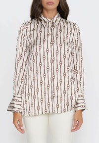 Satinhemd mit einem braunen Kettenglieder-Muster auf cremefarbenem Hintergrund, klassischem Kragen und durchgehendem Knopfverschluss, langen Ärmeln mit weit ausgestelltem Saum.