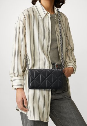 Sac bandoulière en cuir noir matelassé avec une chaîne comme bandoulière, forme rectangulaire, présentant un motif en losanges et une texture lisse.