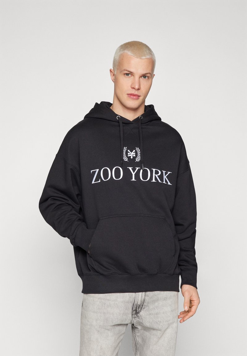 Zwarte hoodie met het "ZOO YORK" logo in wit. Bevat een voorzak, verstelbare trekkoordkap, en ribgebreide manchetten en zoom. Gladde textuur.