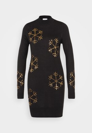 Mustat neulottu mekko korkealla kauluksella, jossa on kultaiset paljettilumihiutalemallit edessä ja hihoissa.