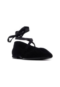 Bailarinas de ante negro con punta afilada, que cuentan con tiras entrelazadas y pliegues sutiles en la parte delantera. Suela plana con hardware mínimo.