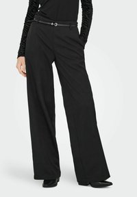Czarne spodnie typu wide-leg o gładkiej fakturze, z przednimi kieszeniami i wąskim czarnym paskiem z detalem w postaci srebrnej klamry.