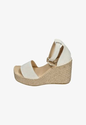 White wedge sandals with suede straps and an espadrille-style jute sole. Features an adjustable ankle strap and a smooth texture.