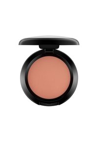 Compact de blush rond avec une finition noire mate. L'intérieur révèle une poudre douce de teinte pêche avec une texture de surface nervurée. Le couvercle est partiellement ouvert.